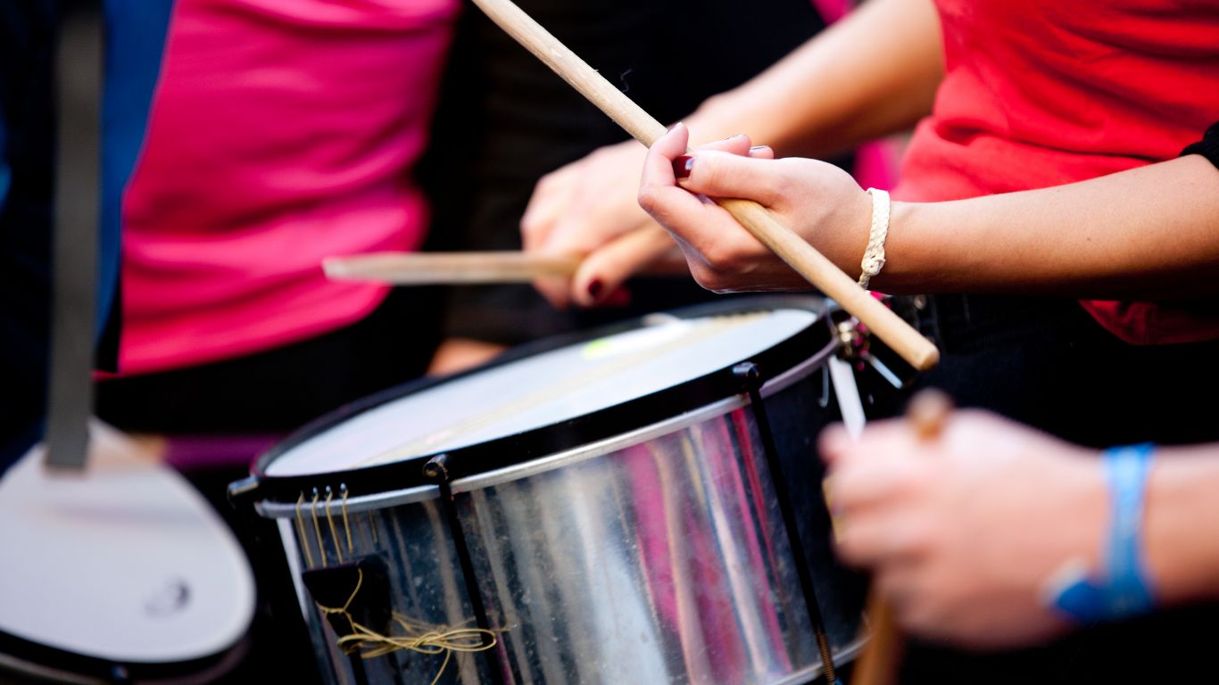 Personas tocando batucada con baquetas